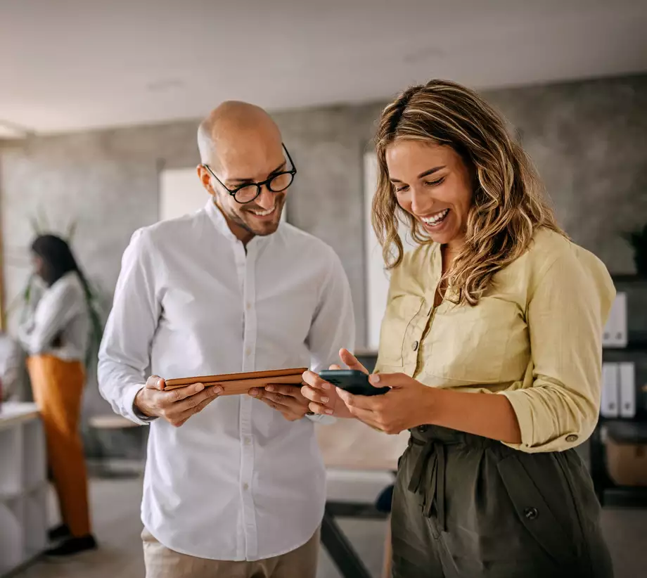 Un homme et une femme dans un bureau qui regardent une tablette