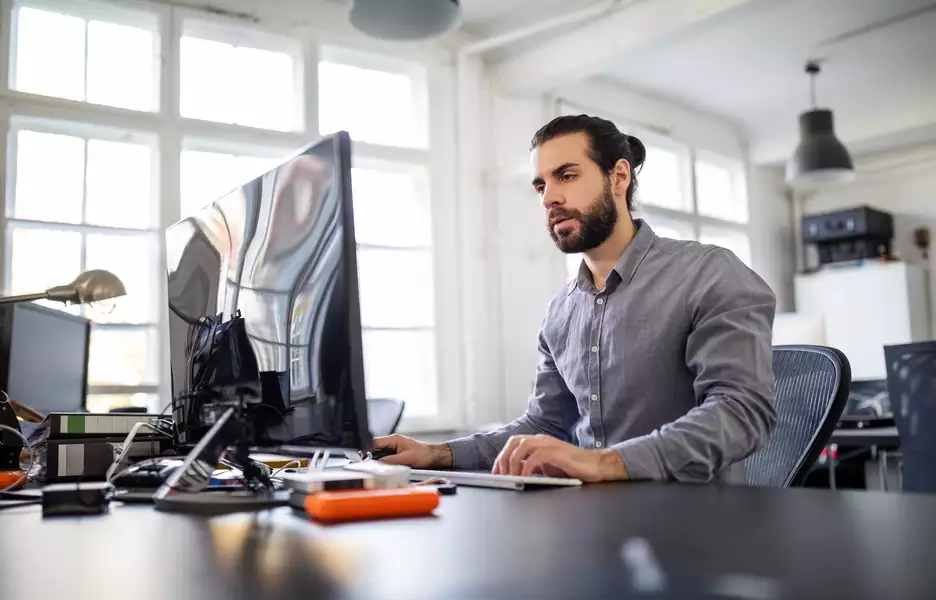 Un homme qui travaille derrière son ordinateur